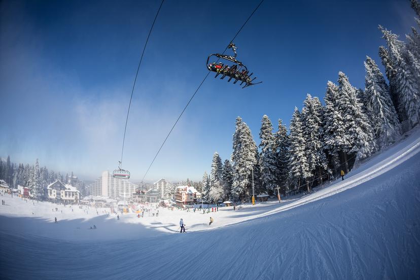 Skiers taking chairlift to top of mountain in Borvoets ski resort Bulgaria